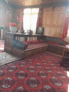 sala de estar con sofá sobre alfombra roja en Alif Laila Group of Houseboats, Srinagar, en Srinagar