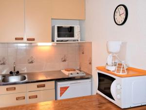 a small kitchen with a sink and a microwave at Studio 4 pers proche remontées, commerces, animaux admis - Risoul 1850 - FR-1-330-123 in Risoul
