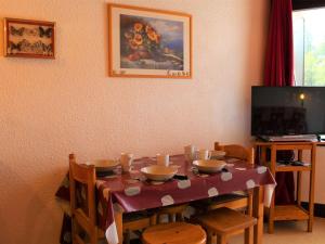 una sala da pranzo con tavolo, sedie e TV di Appartement Vars, 1 pièce, 4 personnes - FR-1-330B-38 a Vars