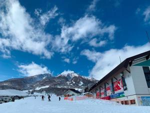 un grupo de personas esquiando en una montaña cubierta de nieve en Villa Monrepos, en Myoko