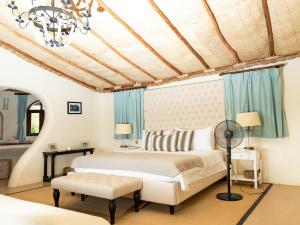 Schlafzimmer mit einem Bett und blauen Vorhängen in der Unterkunft Olarro Plains in Masai Mara