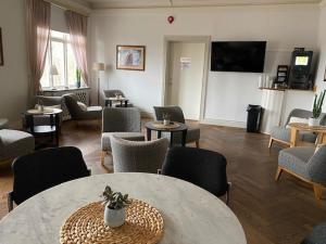 a living room with a table and chairs and a tv at Adels Hotel in Oskarshamn