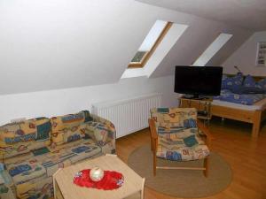 uma sala de estar com dois sofás e uma televisão em Rügen Fewo 38 em Dreschvitz