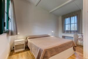 ein weißes Schlafzimmer mit einem Bett und einem Fenster in der Unterkunft Grotta del Saraceno in Vasto