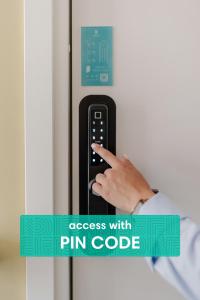 a hand is pressing a pin code on a refrigerator door at Revelton Suites Tallinn in Tallinn