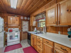 een keuken met houten kasten, een wastafel en een fornuis bij Ons Huis Cabin in Carnelian Bay