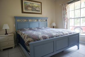 una camera con un letto blu e una finestra di Villa Susanne a Lehigh Acres