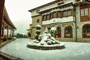 a building with a snow covered fountain in front of it at The House of the Miyaks in Rostuša