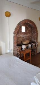 um quarto com uma lareira de tijolos e uma cama em B&B La Verna em Casola