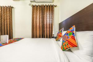 a bedroom with a bed with white sheets and pillows at FabHotel RMS Comforts Yeshwantpur in Bangalore