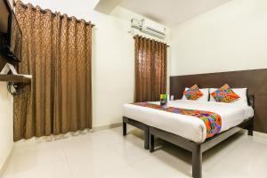 1 dormitorio con cama y ventana en FabHotel RMS Comforts Yeshwantpur en Bangalore