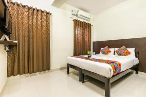 a bedroom with a bed and a window at FabHotel RMS Comforts Yeshwantpur in Bangalore
