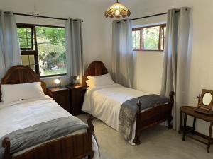 a bedroom with two beds and a window at Rest@Kommetjie in Cape Town