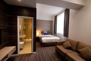 um quarto de hotel com uma cama e um sofá em The Wesley Euston em Londres