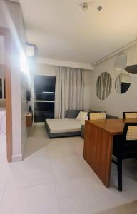 a living room with a bed and a desk in a room at Salinas Exclusive Resort - Apto 1Q in Salinópolis