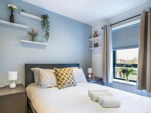 a bedroom with a bed with blue walls and a window at Pass the Keys Stunning 2BR Apt w Balcony Views City Centre in Belfast