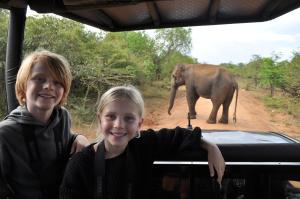 dwójka dzieci stojących w samochodzie z słoniem w tle w obiekcie Mahoora - Yala by Eco Team w mieście Yala