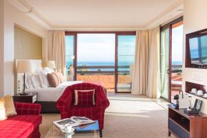 a hotel room with a bed and a living room at Kempinski Hotel Bahía Beach Resort & Spa in Estepona