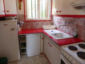 een kleine keuken met een wastafel en rode tegels bij Appartement Le Lavandou, 2 pièces, 2 personnes - FR-1-308-35 in Le Lavandou