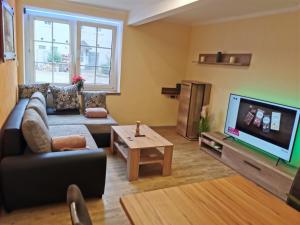 a living room with a couch and a tv at Gästewohnung Schönfeld in Frohburg