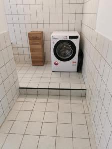y baño alicatado con lavadora y secadora. en Gästewohnung Schönfeld, en Frohburg