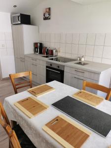 uma cozinha com uma mesa com 2 cadeiras e um fogão em Gästewohnung Schönfeld em Frohburg