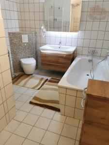 a bathroom with a tub and a toilet and a sink at Gästewohnung Schönfeld in Frohburg