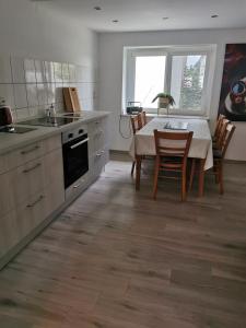 a kitchen with a table and chairs and a kitchen with a table and a table at Gästewohnung Schönfeld in Frohburg