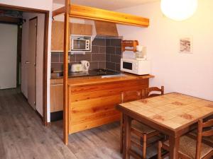 a small kitchen with a table and a microwave at Studio Les Orres, 1 pièce, 4 personnes - FR-1-322-246 in Les Orres