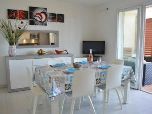 a dining room with a table and white chairs at Spacieux 3 pièces avec terrasse, piscine et garage, à 2 pas de la plage – Saint Raphaël - FR-1-226A-274 in Saint-Raphaël