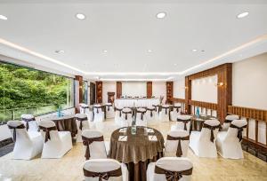 un salón de banquetes con mesas y sillas en una habitación en GReaT trails Kodaikanal by GRT Hotels, en Kodaikanal