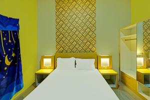 una camera da letto con un grande letto con due luci sopra di OYO 91857 Callista Homestay a Bonthain