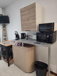 a kitchen with a counter top with a microwave and a microwave at Studio avec parking face a la gare in Nevers