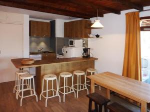 una cucina con bancone con sgabelli e tavolo di Appartement Les Orres, 2 pièces, 6 personnes - FR-1-322-220 a Les Orres