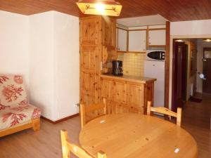 a kitchen and dining room with a wooden table and chairs at Appartement Les Orres, 1 pièce, 4 personnes - FR-1-322-255 in Les Orres