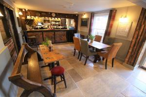 a restaurant with a table and chairs and a bar at The Carpenters Arms in Newbury