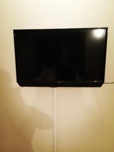 a flat screen tv hanging on a wall at Hill view Guest House near continental bakery Johar Darul sehat, Agha khan and Liaqat Hospital in Karachi
