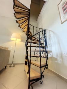 a spiral staircase in a living room with a lamp at Villa Corfou in Corfu