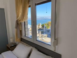 una camera da letto con finestra affacciata sull'oceano di Sunset view Rooms a Agia Triada