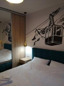 - une chambre avec un lit et une photo de téléphérique dans l'établissement Apartman Sihrovski - Vila Pekovic Blue Zlatibor, à Zlatibor