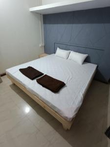 - un lit avec 2 serviettes dans une chambre dans l'établissement REVA ROOM'S, à Rājpīpla
