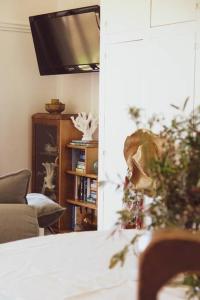 a living room with a couch and a television at Quaint and intimate 1-bed seaside cottage in Bridport