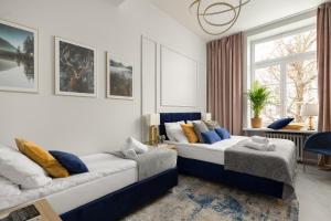 a bedroom with two beds and a living room at Movo Old Town Apartments in Warsaw