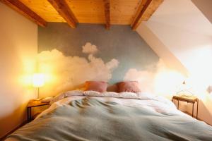 ein Bett in einem Schlafzimmer mit einer Wand mit Wolken-Wandbild in der Unterkunft Gîte Aux Quatre Vents avec Terrasse in Rouffach