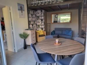 ein Wohnzimmer mit einem Holztisch und blauen Stühlen in der Unterkunft Primavéra in Sanary-sur-Mer