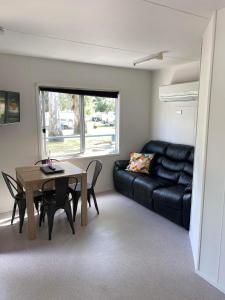 sala de estar con mesa y sofá en Euroa Caravan Park en Euroa