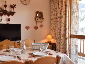 Les AlluesにあるStudio cosy 4 pers, centre Méribel, pistes à 50m, proche commerces et restos - FR-1-180-312のテーブルとテレビのあるダイニングルーム
