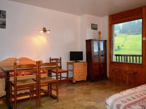 a bedroom with a bed and a desk and a television at Appartement Le Grand-Bornand, 2 pièces, 5 personnes - FR-1-241-147 in Le Grand-Bornand