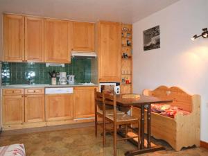a kitchen with wooden cabinets and a table and chairs at Appartement Le Grand-Bornand, 2 pièces, 5 personnes - FR-1-241-147 in Le Grand-Bornand