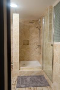 uma casa de banho com um chuveiro e uma cabina de duche em vidro. em Hotel Le Pousse Pousse em Antananarivo